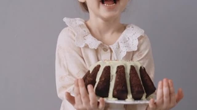 A Child Holding a Cake and Full of Joy