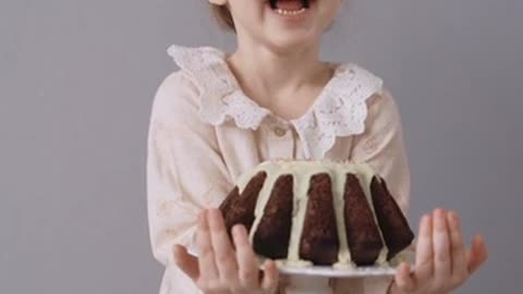 A Child Holding a Cake and Full of Joy