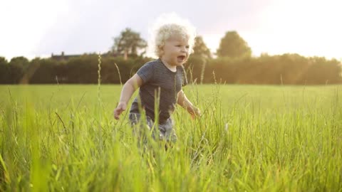 Baby boy playing with grass