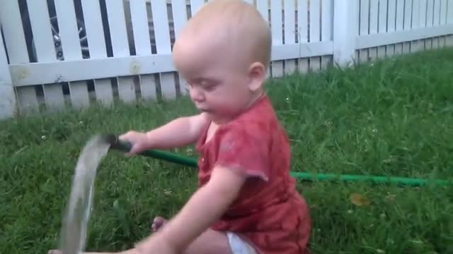 Baby discovers garden hose