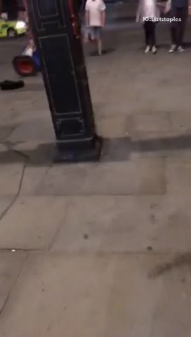 Man in blue jacket talks from orange cone