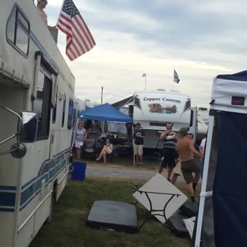 Frat Bro Holding American Flag Leaps From RV On To Flimsy Table