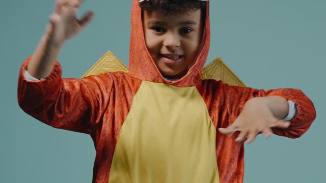 A Boy in Dragon Costume Doing Hand Gestures