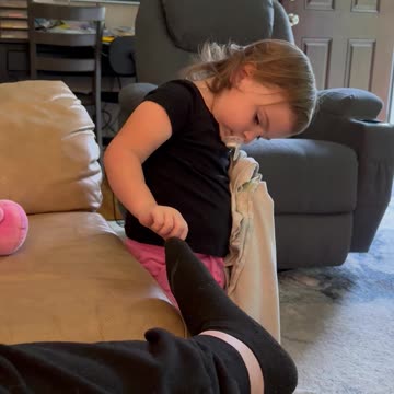 Toddler Trying To Help Mommy With The Hole In Her Sock