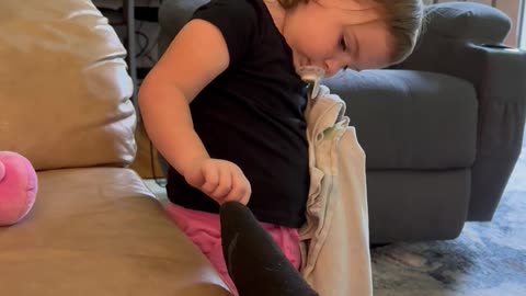 Toddler Trying To Help Mommy With The Hole In Her Sock