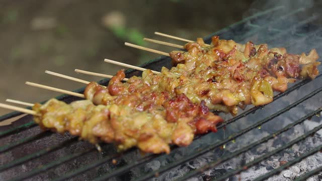 cooking barbecue on stick in a charcoal grill