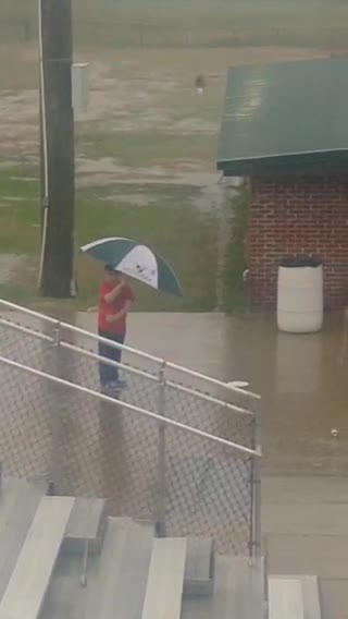 Boy Dances In The Rain Using His Umbrella As A Prop