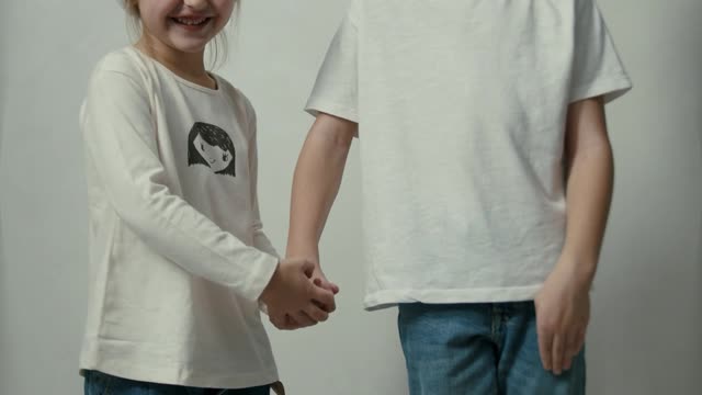 Siblings Posing and Smiling in Front of a Camera