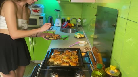 Girl in short skirt cooking baked chicken 