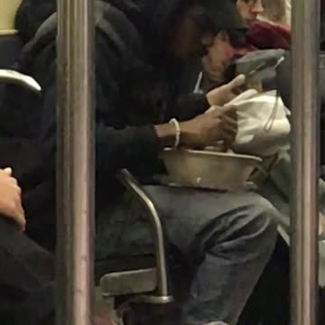 Guy pulls out big bowl of salad and starts eating it on subway