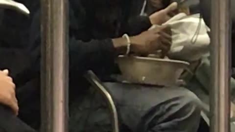 Guy pulls out big bowl of salad and starts eating it on subway