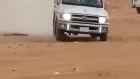 A car running in the desert.