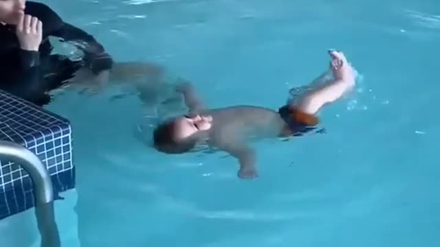 a cute little baby bathing in the swimming pool