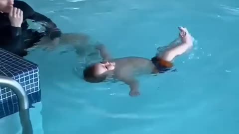 a cute little baby bathing in the swimming pool