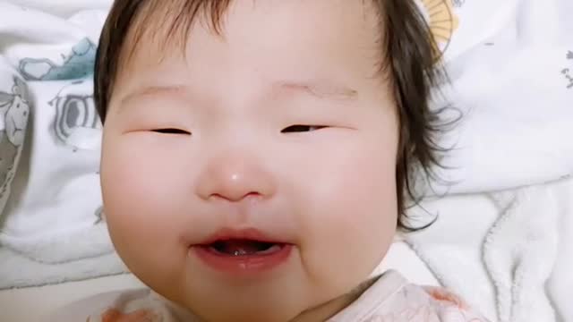 Two-year-old baby smiling brightly at her mother