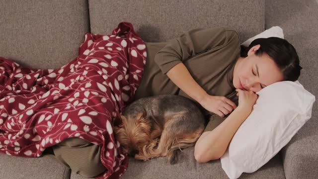 A Woman Sleeping with Her Dog on the Couch