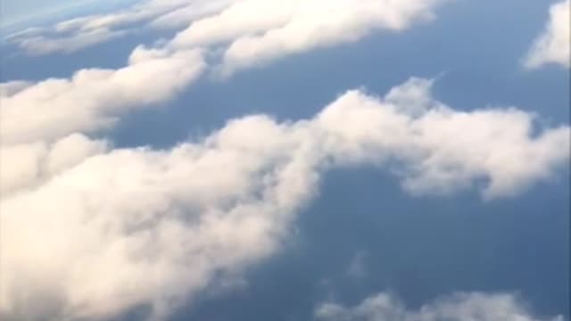an airplane flies over a cloud