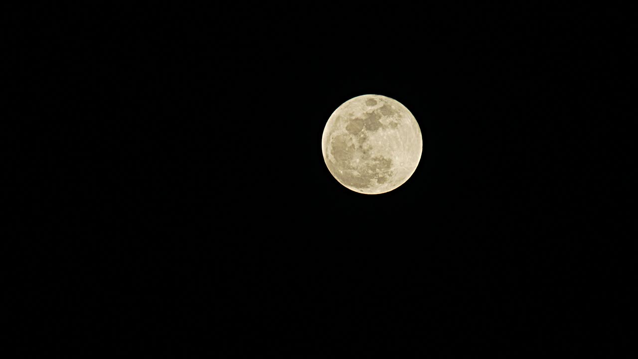 Full moon rising in the dark sky