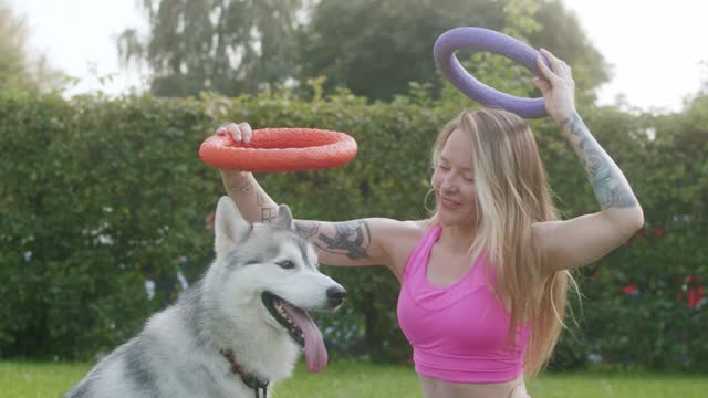 Beautiful girl playing with her dog on home garden