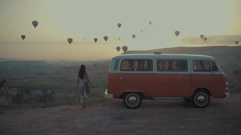 A View Of Hot-Air Balloons In The Air And Woman Riding Her Vehicle