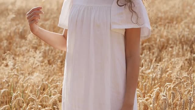 Woman in White Dress Standing in a Wheat Field