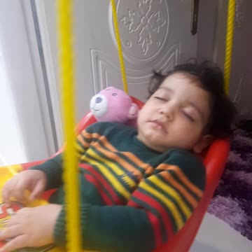 Cute baby sleeping on a swing