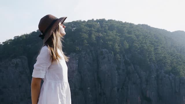 Woman Wearing Hat Standing on a Cliff