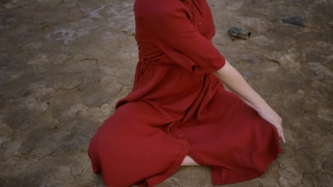 Girl stretching with her body sitting in a desert