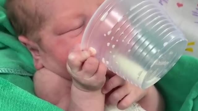 2-days-old baby drinking milk himself