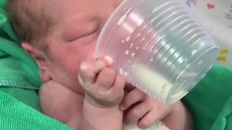 2-days-old baby drinking milk himself