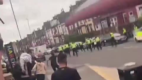 Police run away from migrant mob amid violent unrest in Leeds, England.