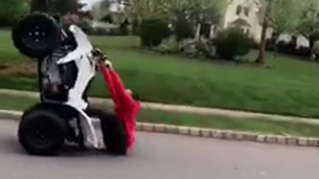 Guy red sweater jacket tries to do wheelie on atv falls on butt