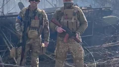 American volunteers in Ukraine show off a destroyed Russian tank.