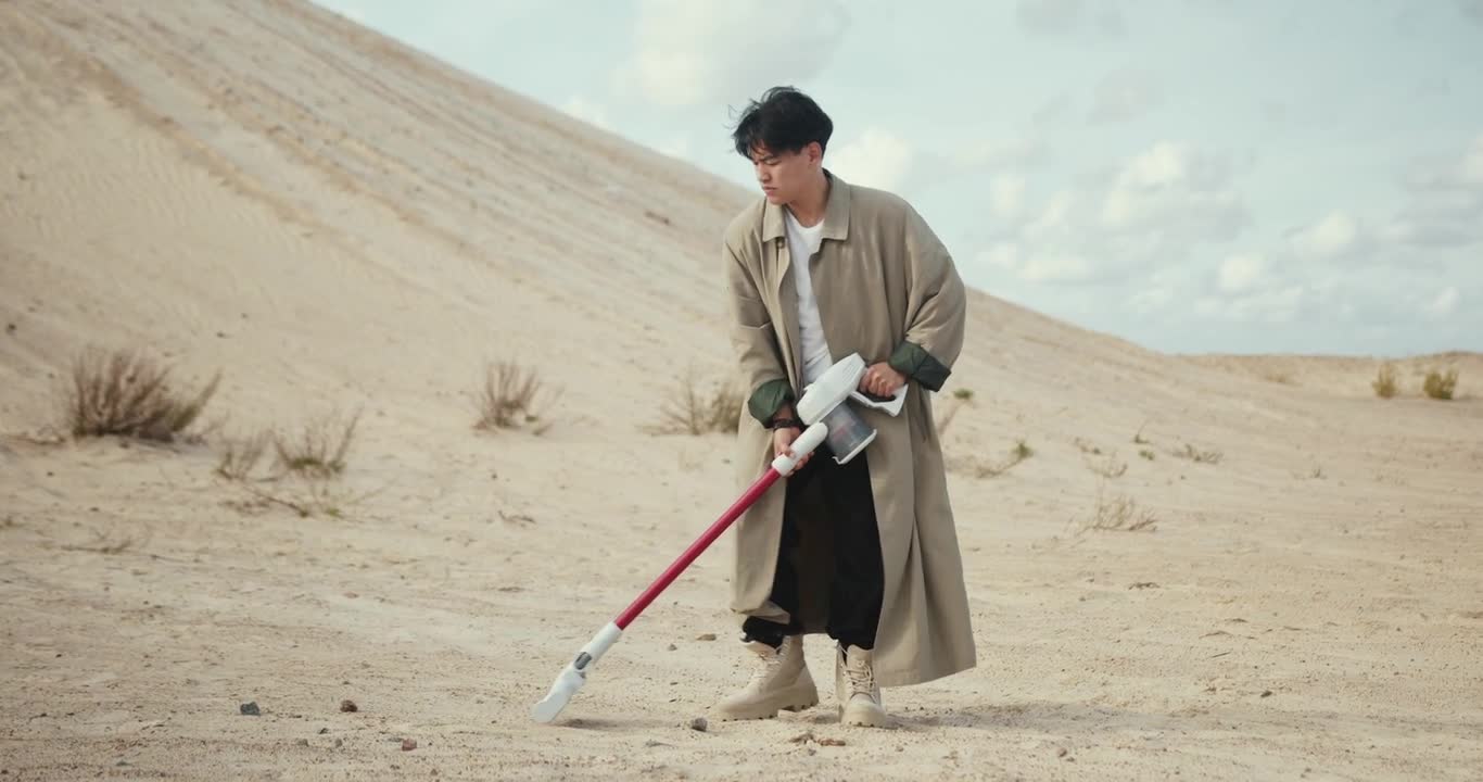 Man using Vacuum Cleaner in Desert