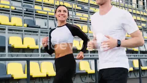 Happy Sportive Couple Talking And Running Together In The Stadium 2