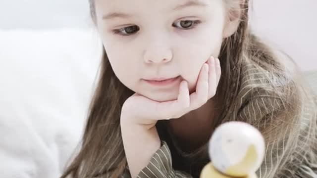 A Girl Is Playing A U-shaped Sorter Wooden Toy ·