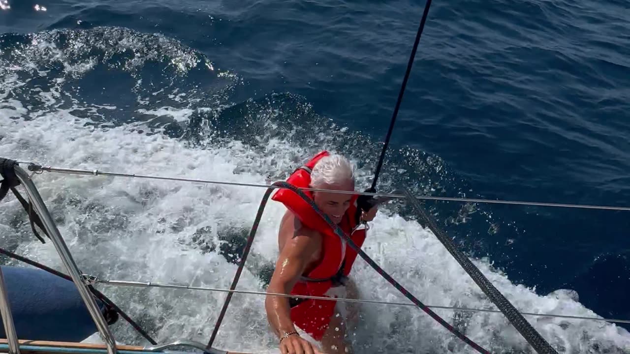 Man Dangles by Rope From Moving Boat