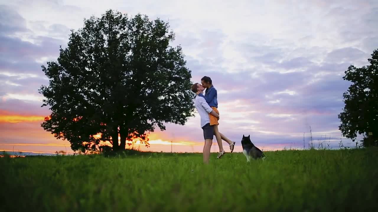 Loving couple playing with dog at the beach. Concept about love, animal and lifestyle