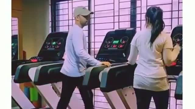 Dashing boy impressing her girl friend with treadmill dance with beautiful song.