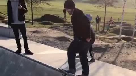 Beanie guy tries to drop in on concrete bowl falls off skateboard
