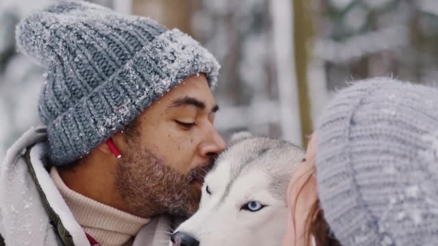 Couple Kissing their Pet Dog