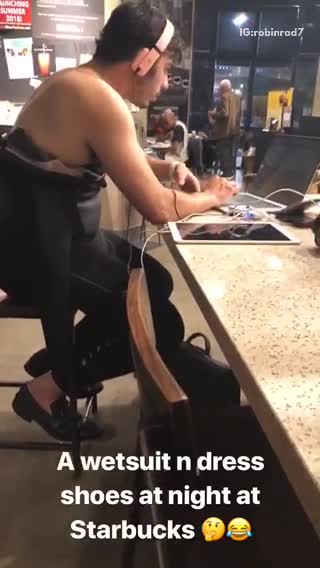 A wetsuit n dress shoes at night at starbucks