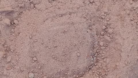 Pouring and mixing of red sand in water