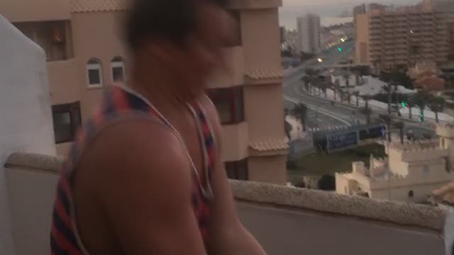 Guy in striped tank top opens beer can with head