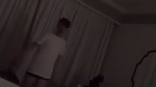 Drunk guy in white shirt stumbles in hotel room