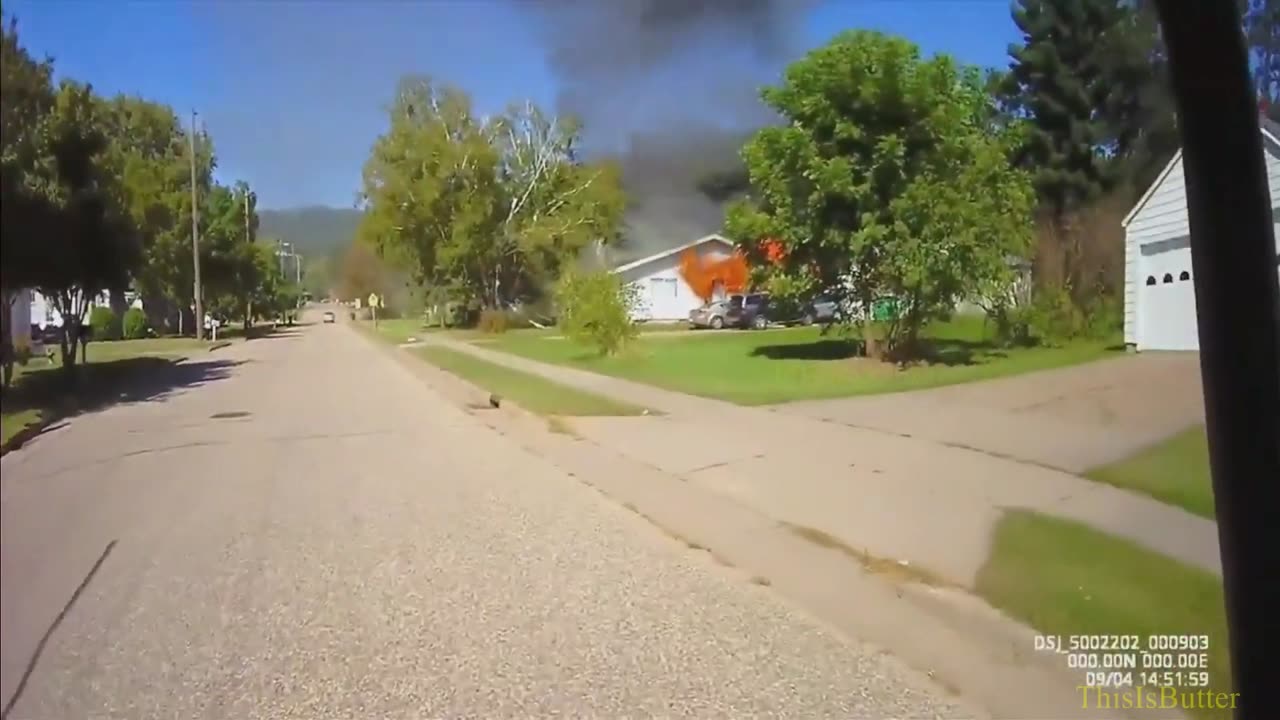 Elk Mound Police Chief Chad Weinberger kicks down the door of a burning home to get the family out