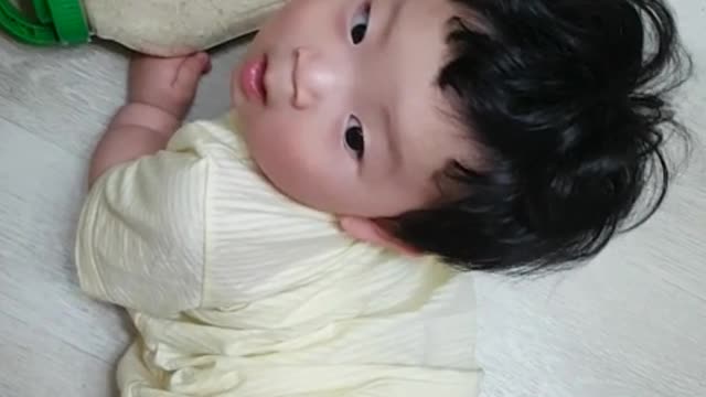 This is a video of a baby having fun rolling a bowl of rice.