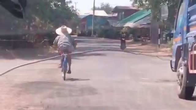 Truck Doesn't Want to Pass Grandma Carrying Stick on a Bike