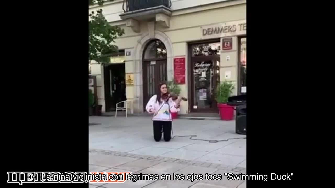 Una niña violinista con lágrimas en los ojos toca Plywe kacha en el centro de Varsovia