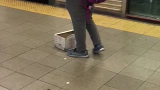 Man in red sweater playing harmonica